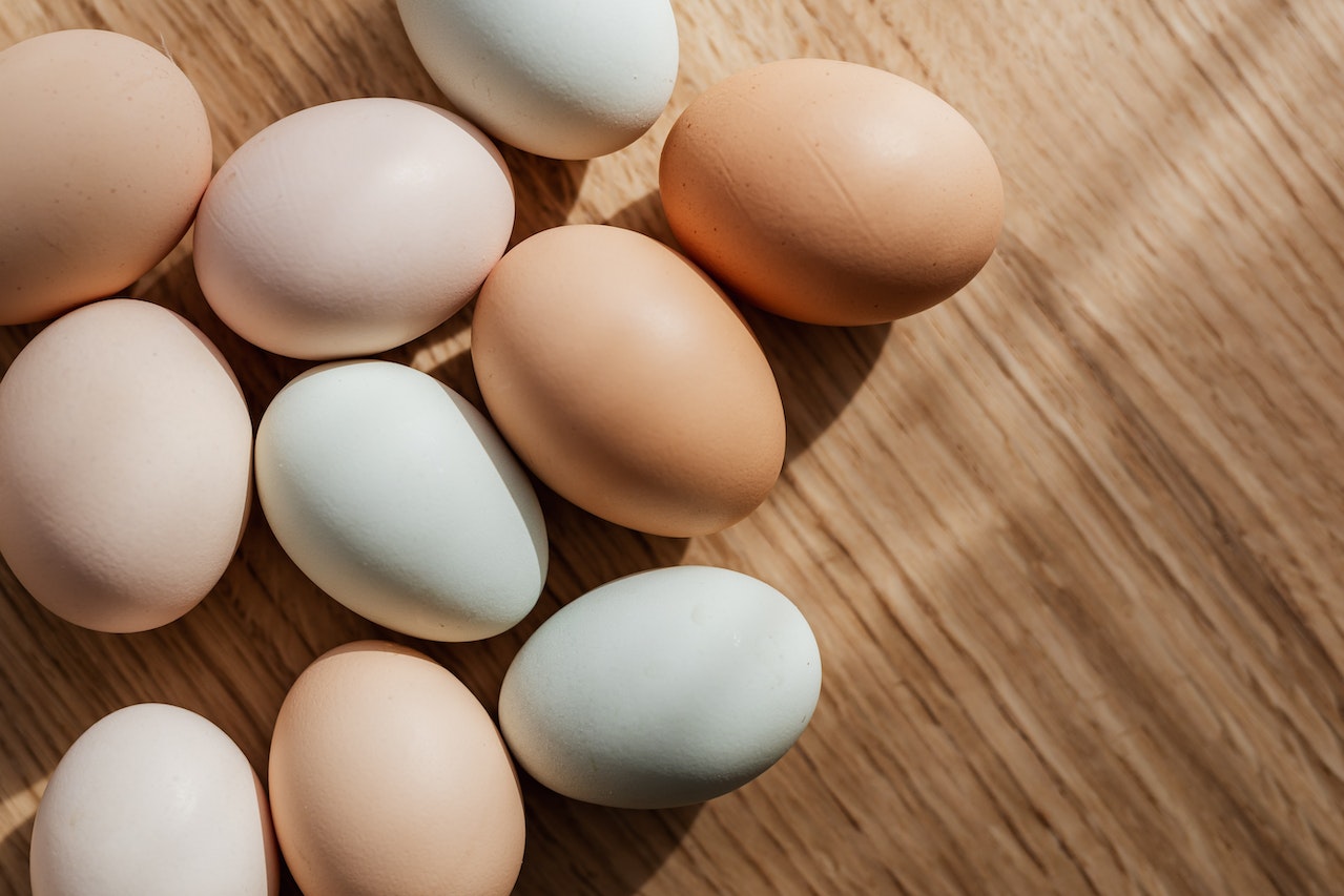 Brown and White Eggs Kept On Wooden Table